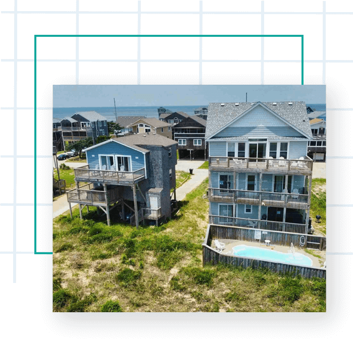 Aerial view of unfinished house with brick walls and wooden roof frame covered with metallic tiles